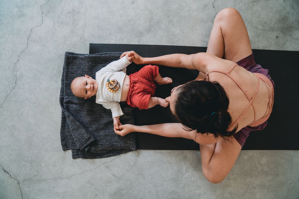 mother having fun with her little kid during a yoga class