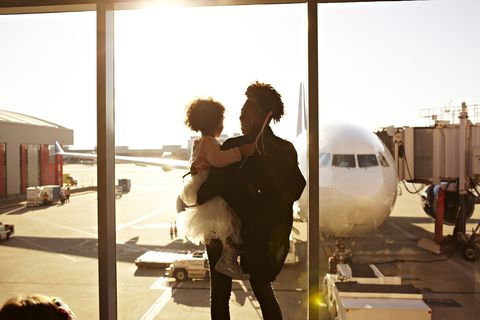 Mother holding daughter at airport