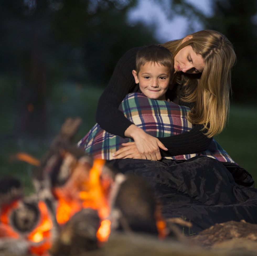 mother hugging son at campfire