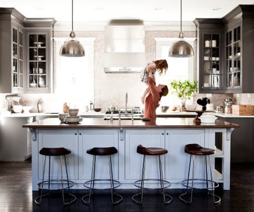 mother lifting daughter in kitchen