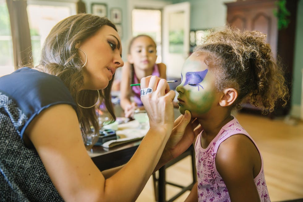 madre pintando caras a los niños en casa