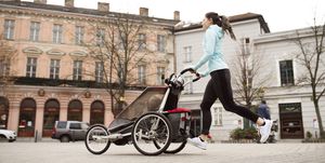 mother running with child in stroller in the city