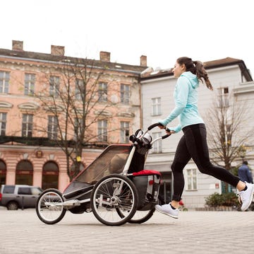 mother running with child in stroller in the city