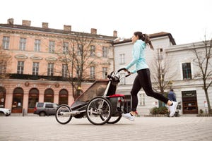 mother running with child in stroller in the city