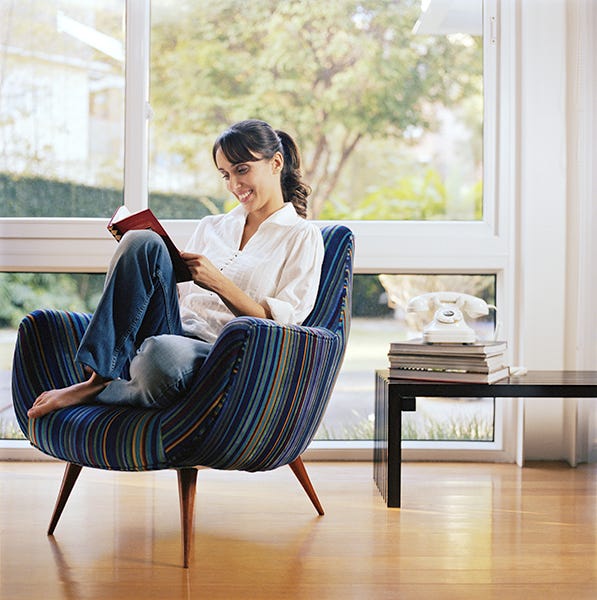 woman reading book in chair starting a book club is a gh pick for best mother's day activities