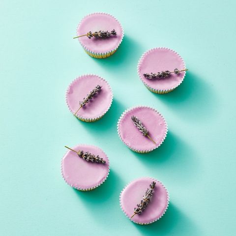 sugared lavender cupcakes with a sprig of lavender on  top  against a blue background