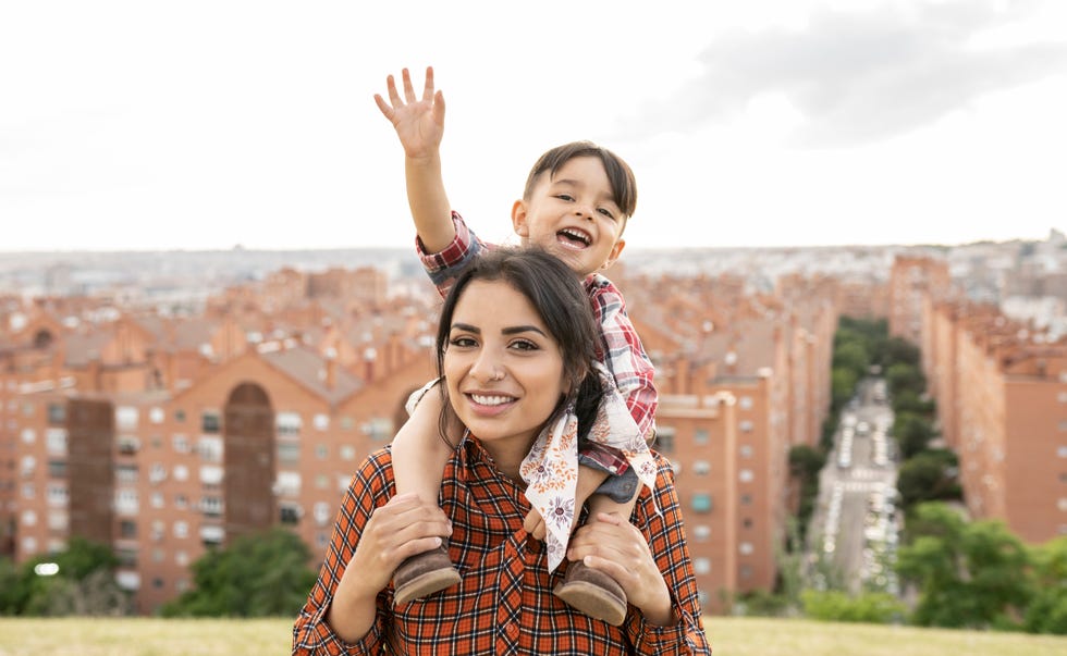 madre con niño feliz a hombros