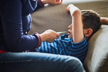 mother taking sons temperature with digital thermometer