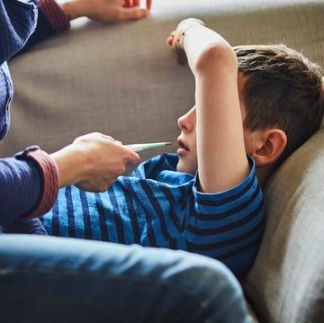 Mother taking sons temperature with digital thermometer mother taking sons temperature with digital thermometer