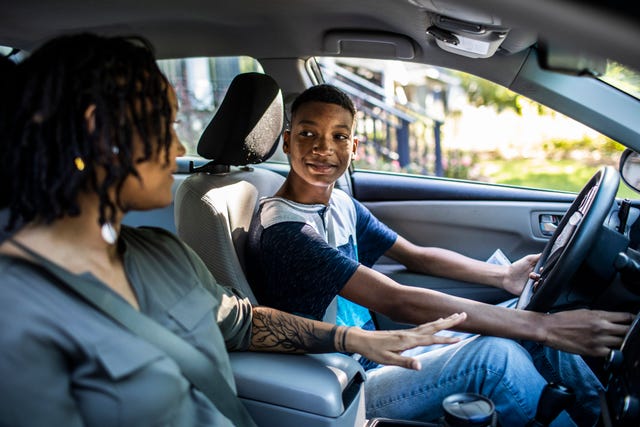 mother teaching teenage son to drive