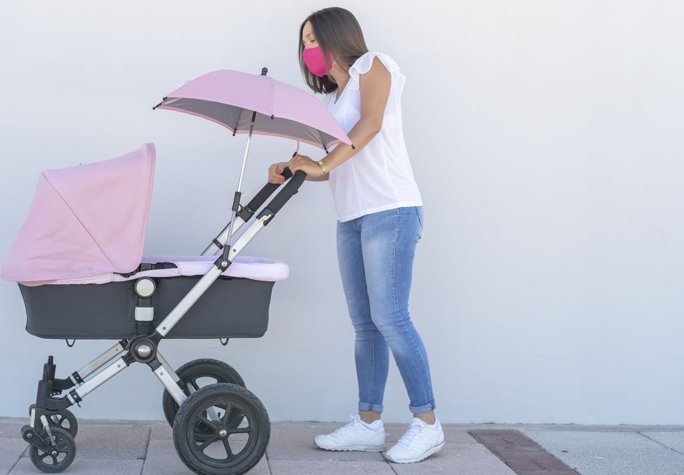 proteger la piel del recién nacido de los rayos de sol es muy importante, usa un carro con sombrilla como hace la madre de la foto al pasear a su bebé