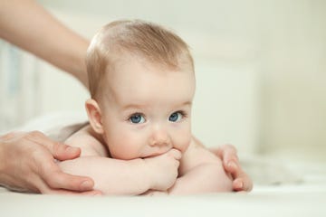 madre con bebe rubio mordiendose la mano