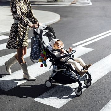 madre con bebé paseando en carrito por ciudad