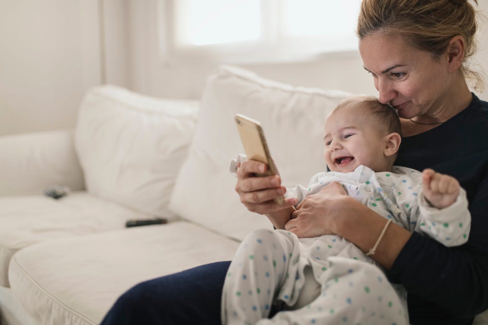 jobs for stay at home moms - Mother with her baby looking a smartphone