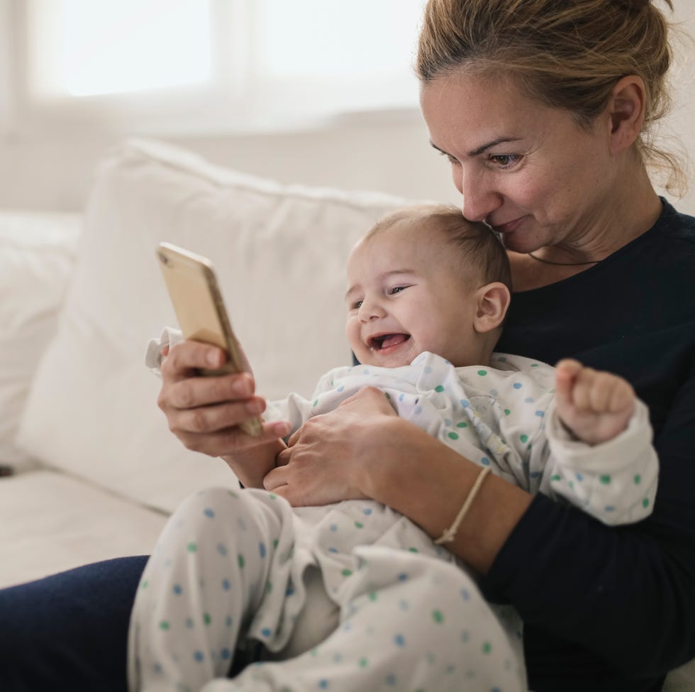 jobs for stay at home moms - Mother with her baby looking a smartphone