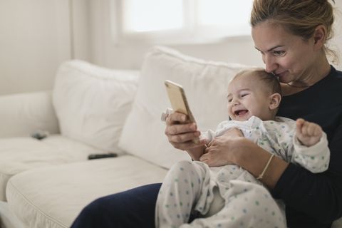 jobs for stay at home moms - Mother with her baby looking a smartphone