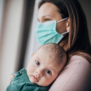 Mother with protective mask holding his baby son at home do to pandemic outbreak mother with protective mask holding his baby son at home do to pandemic outbreak