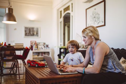 jobs for stay at home moms - Mother on a computer with child nearby