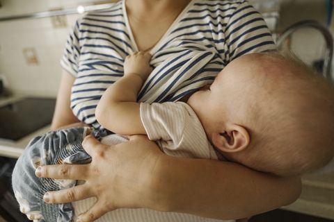 mother's carrying toddler and breastfeeding at home