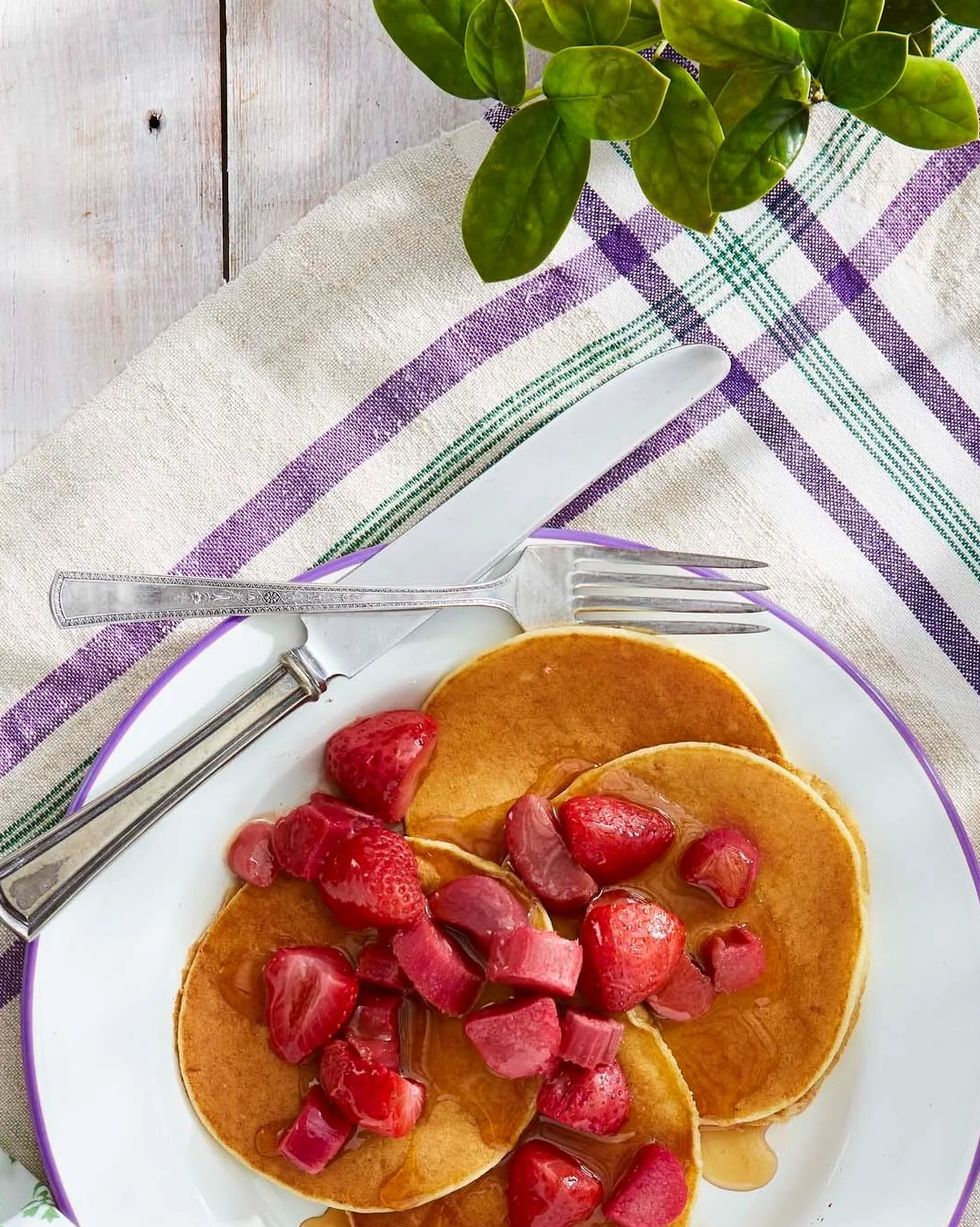 ricotta pancakes with roasted maple rhubarb and strawberries on a plate