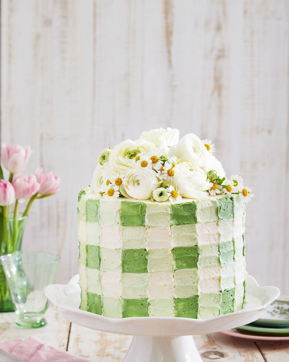 coconut cream cake with green gingham patterned frosting and fresh flowers on top