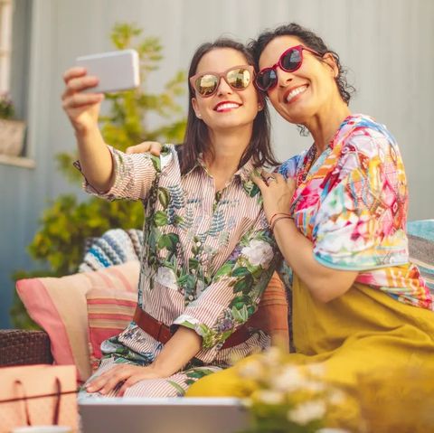 mother and adult daughter wearing sunglasses taking a selfie