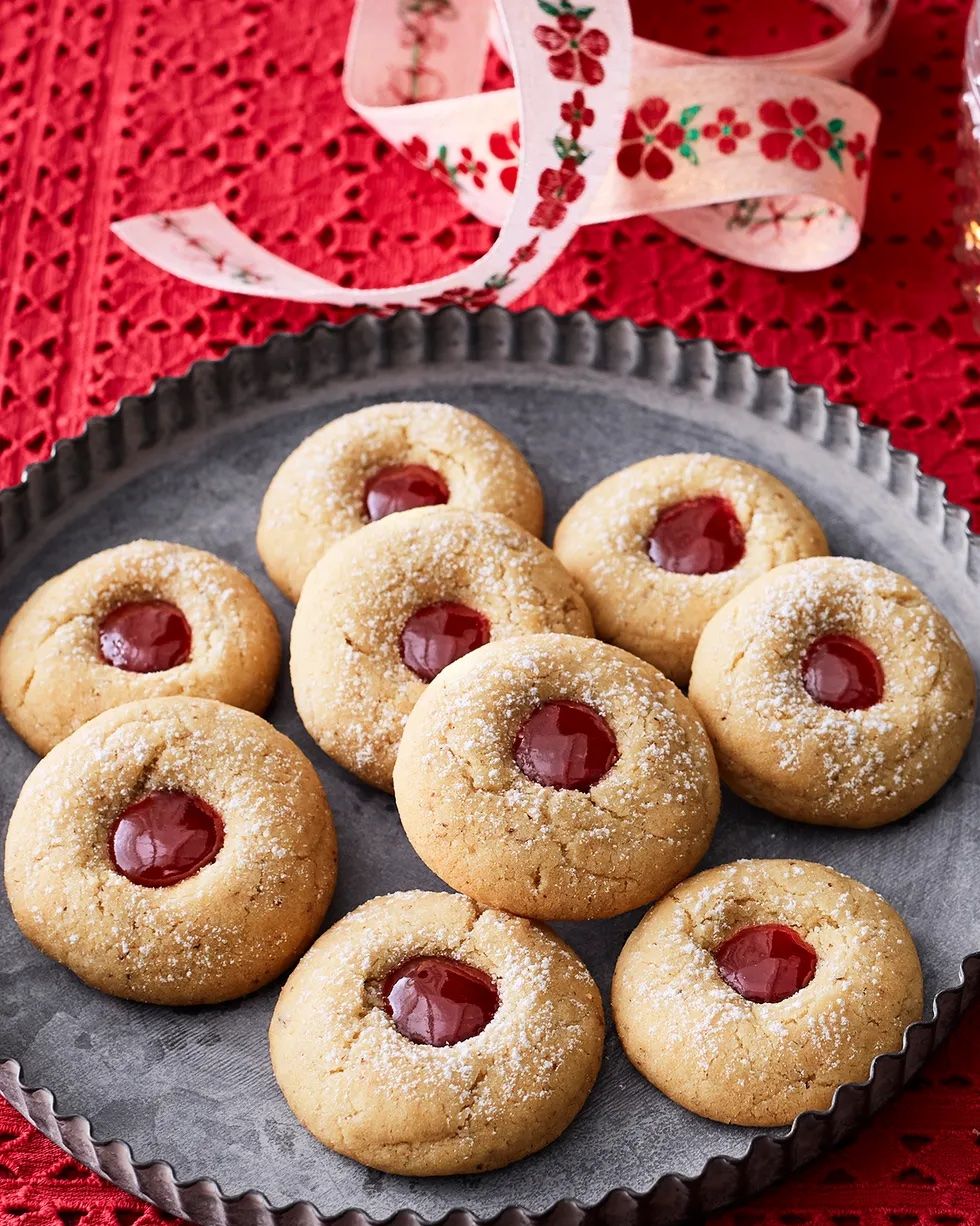 almond raspberry thumbprint cookies on metal tray red background