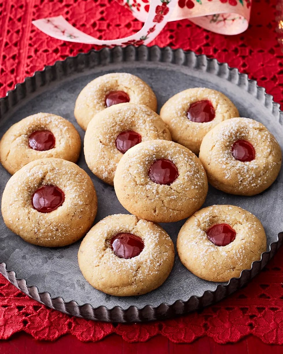 almond raspberry thumbprint cookies on metal tray red background