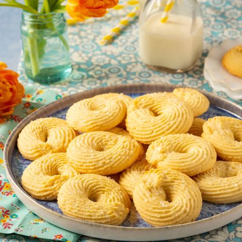 danish butter cookies on plate with jug of milk in back