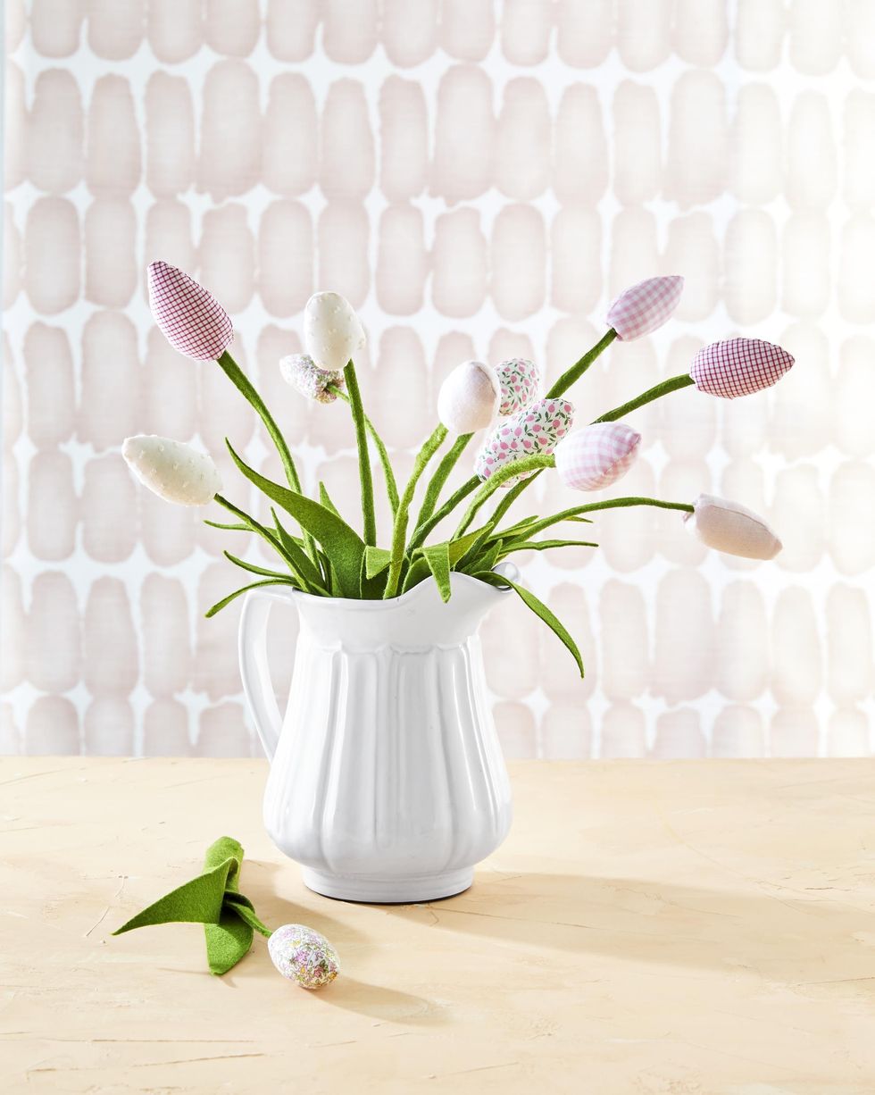 faux tulips with blooms made from pink and white solid, gingham, and floral patterned fabrics attached to wired green felt stems, displayed in white ceramic pitcher
