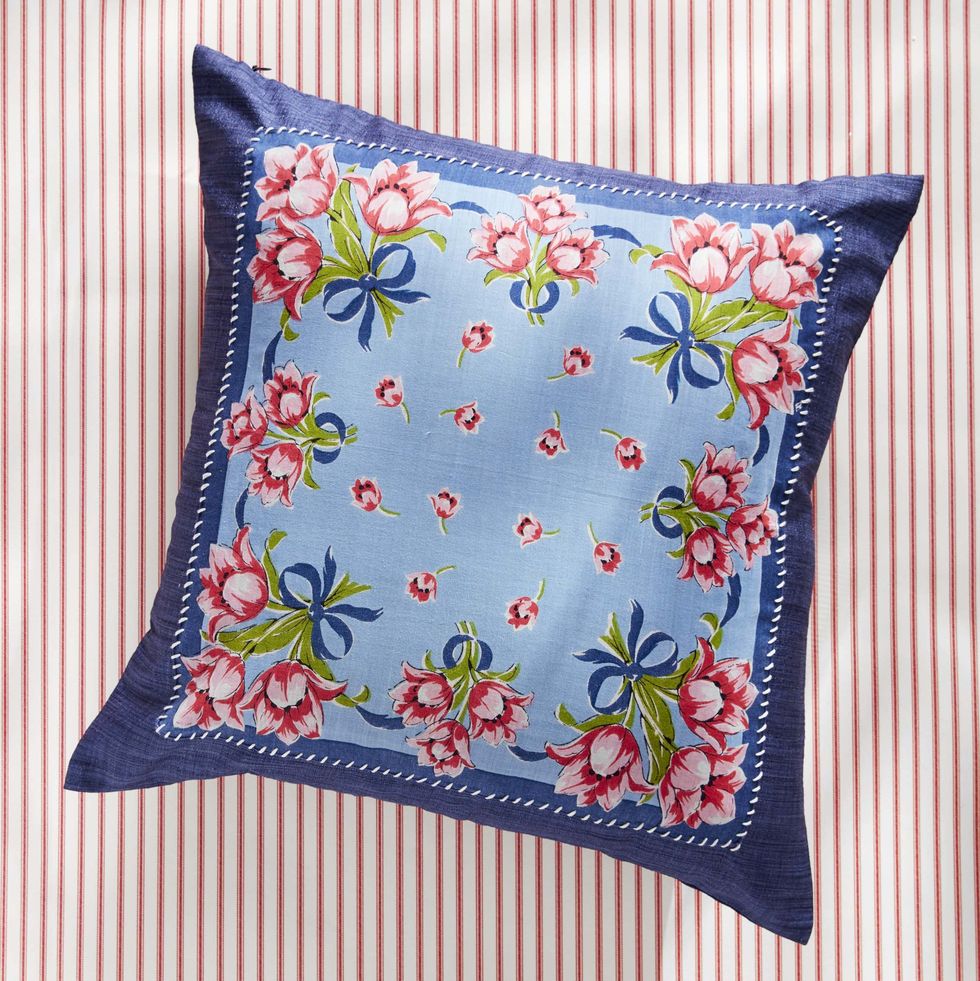 navy throw pillow with a blue, pink, and green floral handkerchief whipstiched to the front