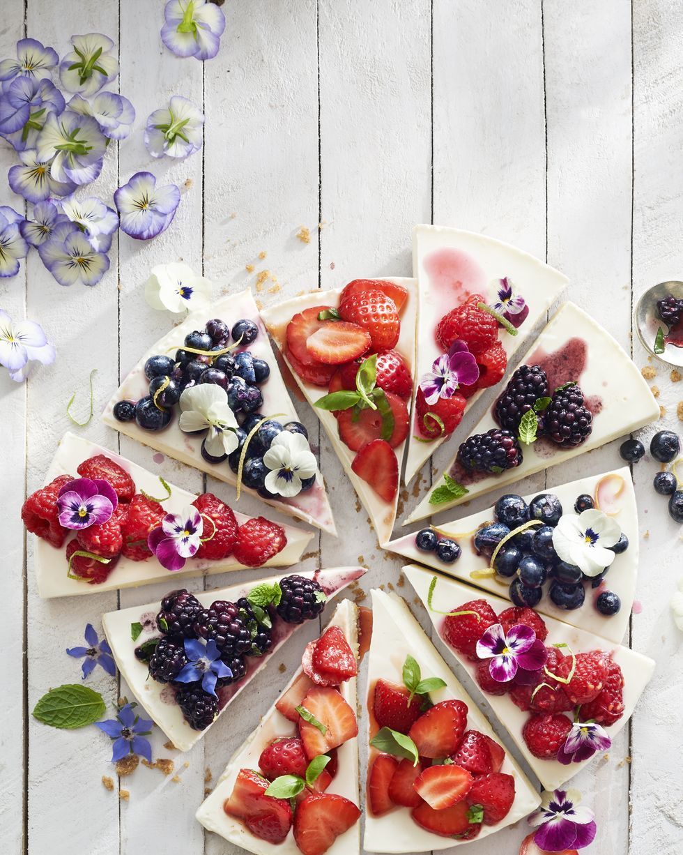no bake cheesecake cut into slices with various berry toppings on each slice
