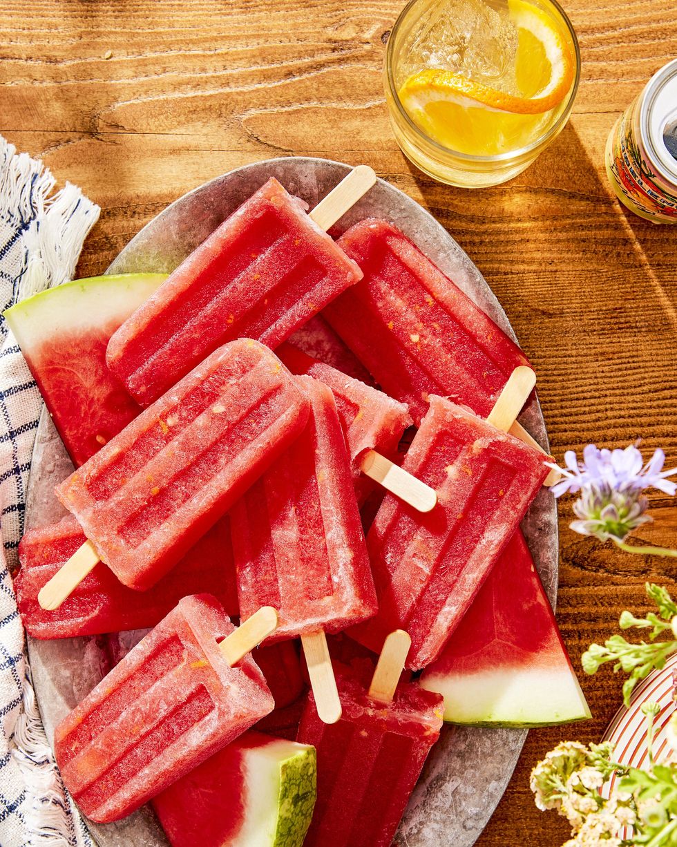 watermelon amaro pops arranged in a metal oval serving dish with fresh sliced of watermelon