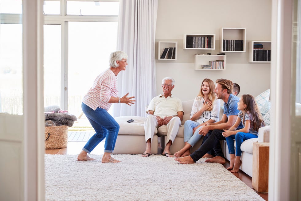 multi generation family sitting on sofa at home playing charades