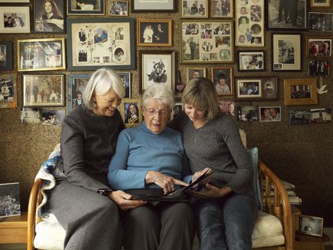 three generations of women looking at photo album