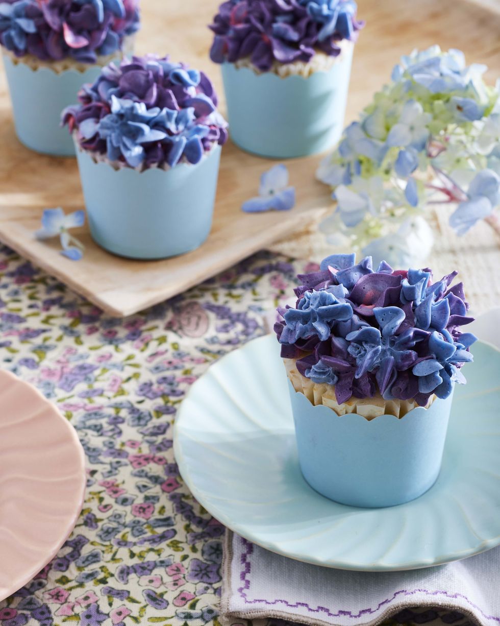 cupcakes with purple pink and blue frosting that is piped to look like hydrangea blooms