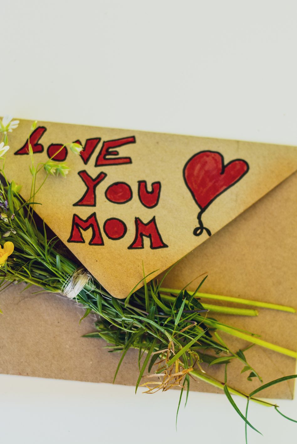 mother's day greeting envelope and a bouquet of flowers, on white background