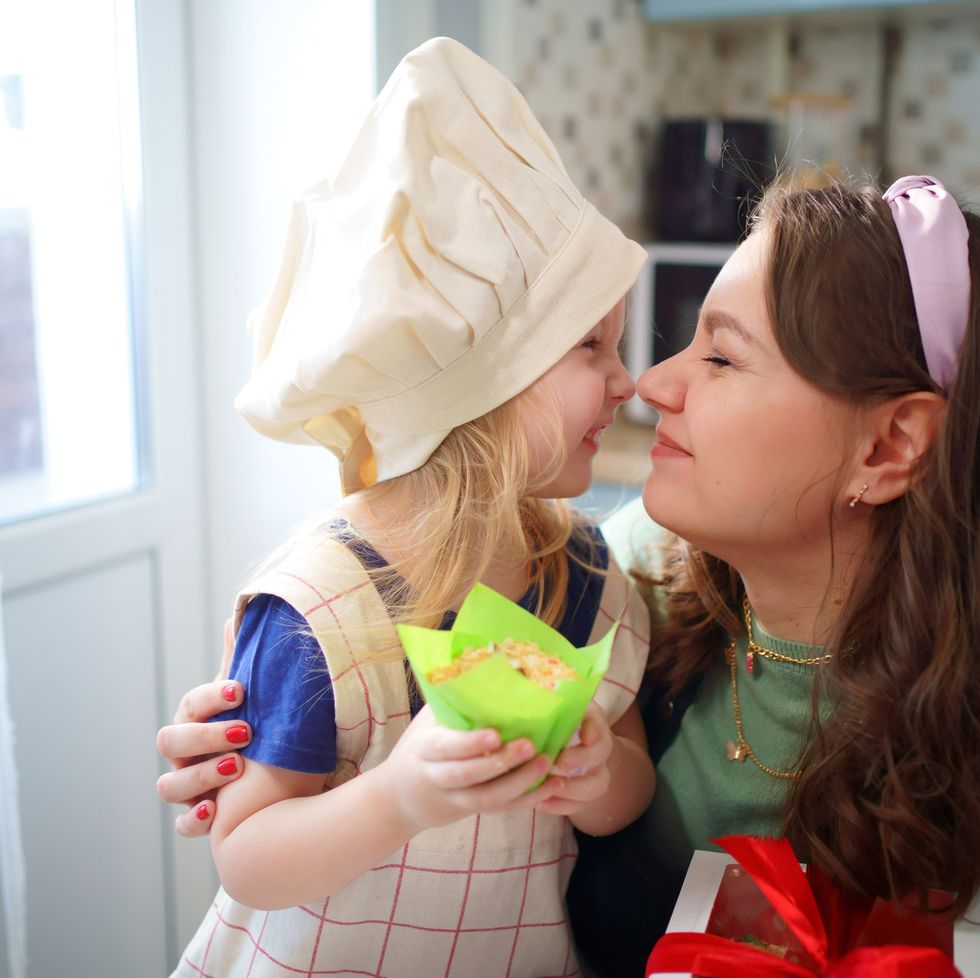 mother and daughter rub noses in the kitchen