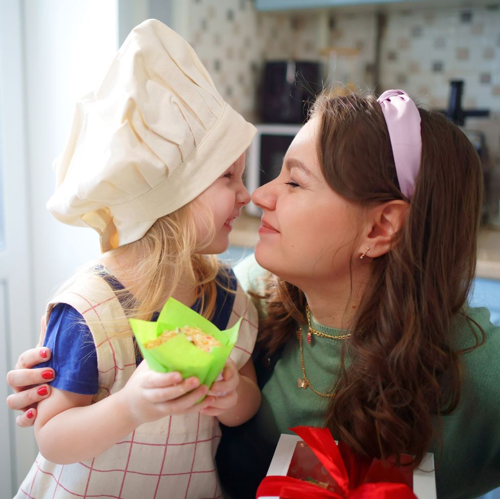 mother and daughter rub noses in the kitchen