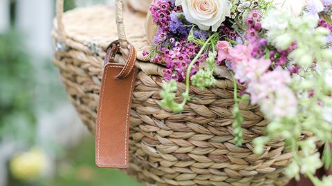 woman holding picnic basket with flowers in it