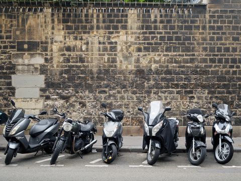 motorcycles lined up against a brick wall