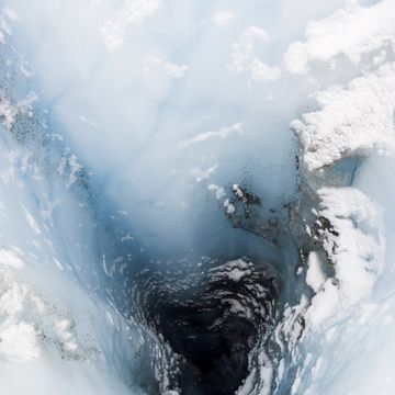 a moulin is a narrow, tubular chute or crevasse through which water enters a glacier from the surface