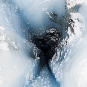 a moulin is a narrow, tubular chute or crevasse through which water enters a glacier from the surface