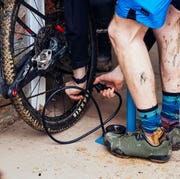 a mountain biker pumping air into a rear tire