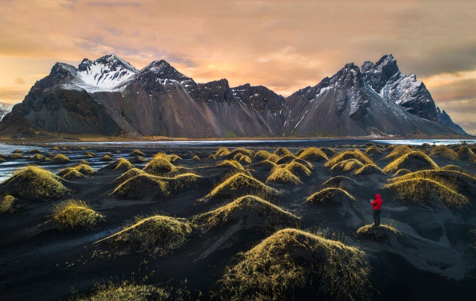 Deze afbeelding is de nieuwste aanwinst in mijn Dronieserie Droneselfie We gingen vorig jaar ook al naar de Vestrahorn maar toen kon ik vanwege het slechte weer niet met mijn drone vliegen Ik wist dat ik nog eens terug wilde keren om een foto vanuit de lucht te maken van dit schitterende landschap Dit jaar gingen we in maart weer en dit keer werkte het weer gelukkig wel mee Ik heb geprobeerd dit schitterende landschap met behulp van een drone op een unieke manier in beeld te brengen We zijn alweer plannen aan het maken voor een volgende reis want we zijn verliefd op IJsland