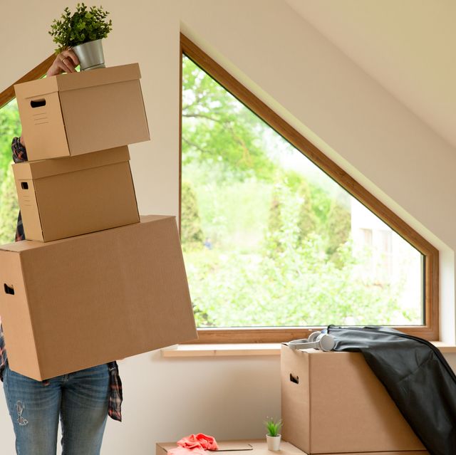 move. cardboard boxes for moving into a new, clean home. in a sunny day by a window in attic.