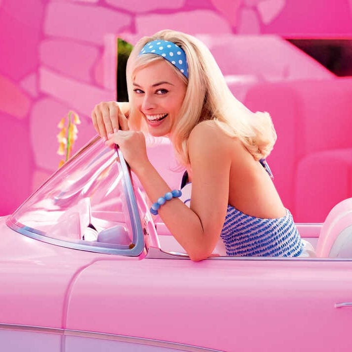 Barbie drives a pink car in a scene from Barbie, a Good Housekeeping pick for best kids' movies 2023 barbie drives a pink car in a scene from barbie, a good housekeeping pick for best kids' movies 2023