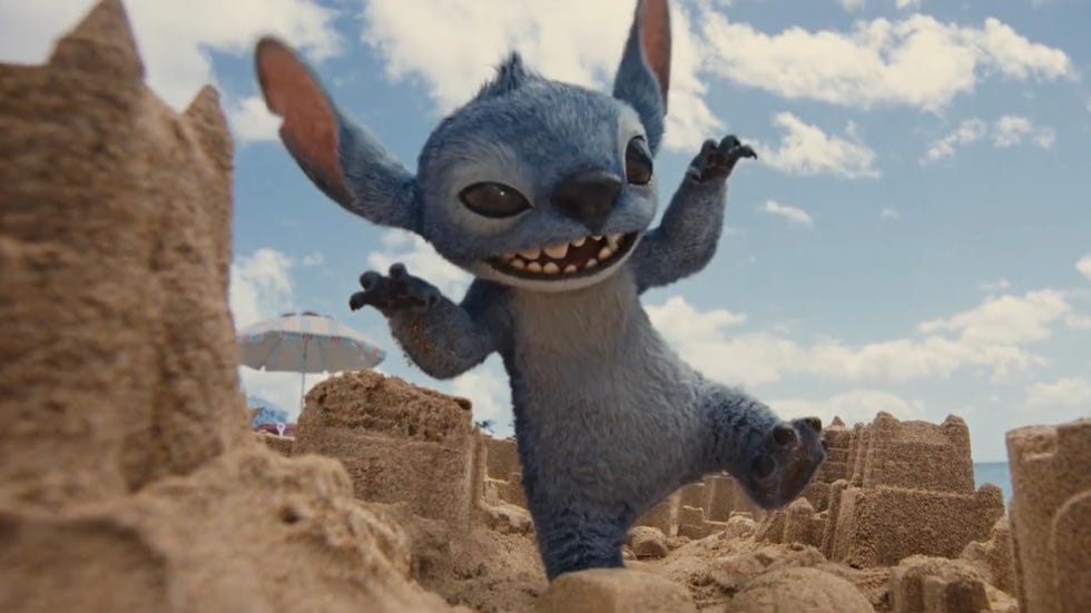 a cgi stitch stamps a sand city with a mischievous grin on his face in a scene from lilo and stitch, a good housekeeping pick for best kids' movies 2025