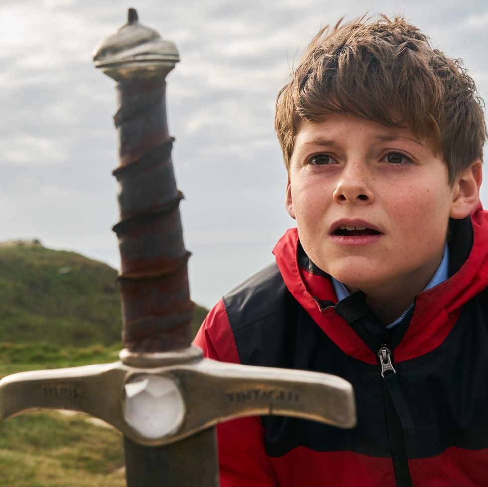 a tween stares at a sword in a scene from the kid who would be king, a good housekeeping pick for best tween movies