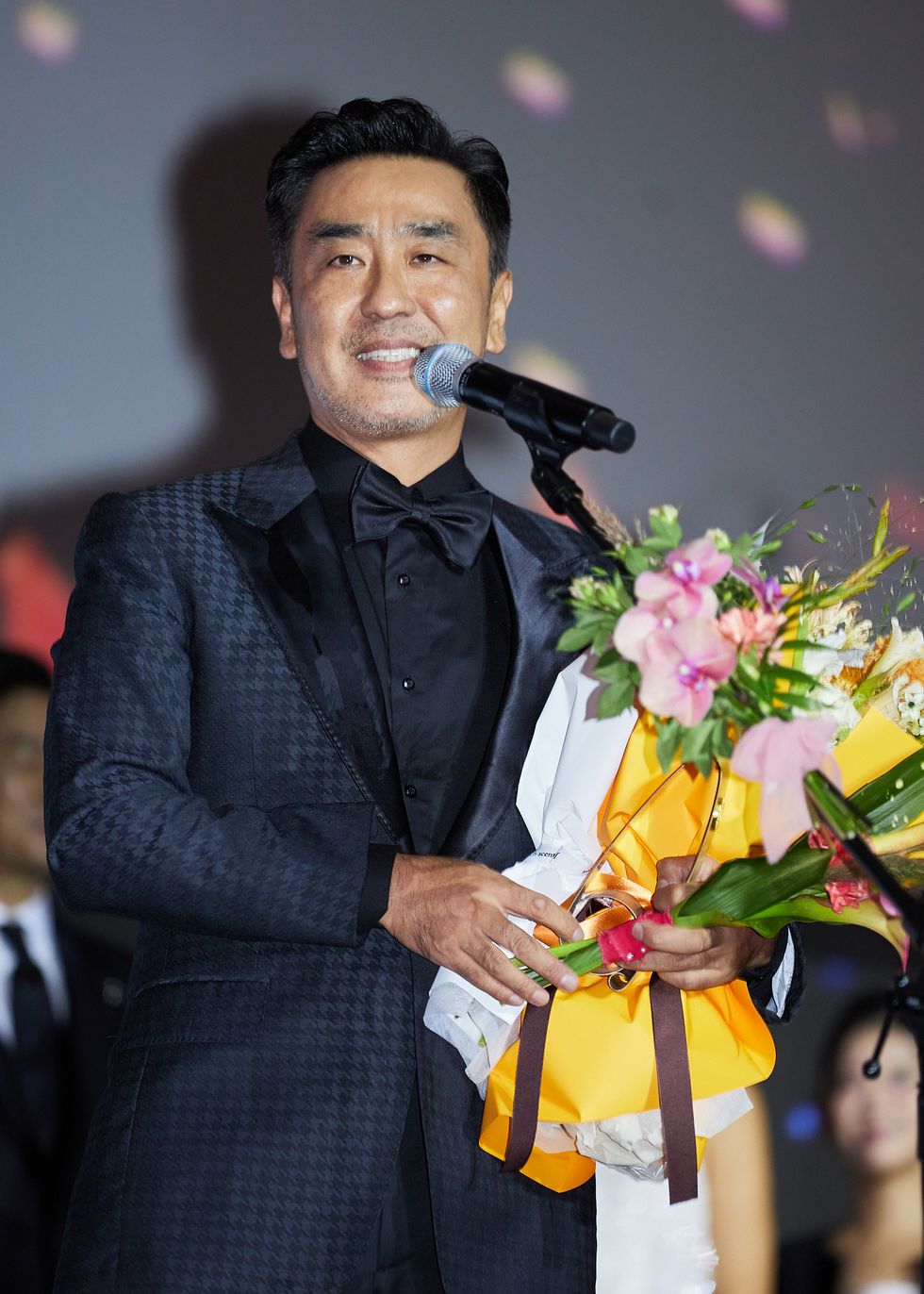 a man holding flowers and smiling